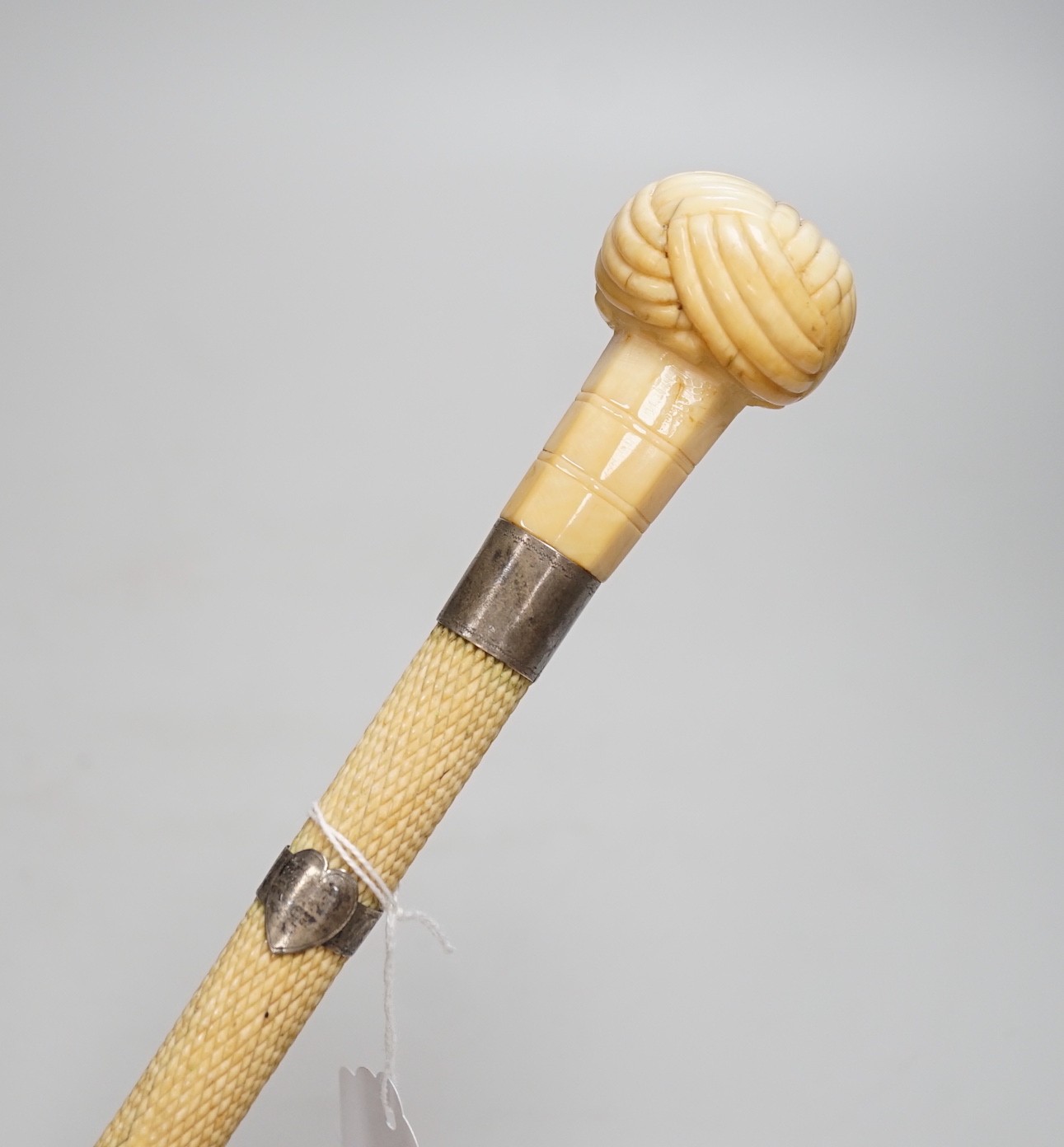 A 19th century scrimshaw whalebone walking cane with white metal mounts, length 69cm